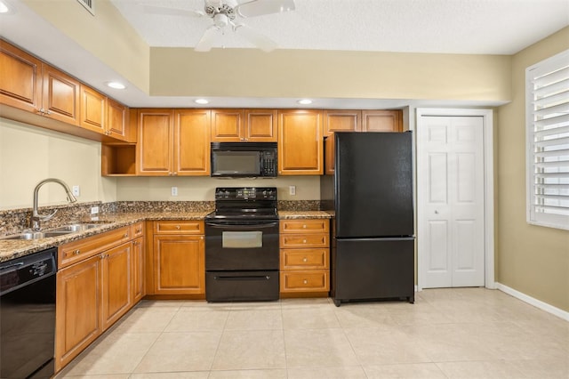 kitchen with light tile patterned floors, stone countertops, sink, black appliances, and ceiling fan