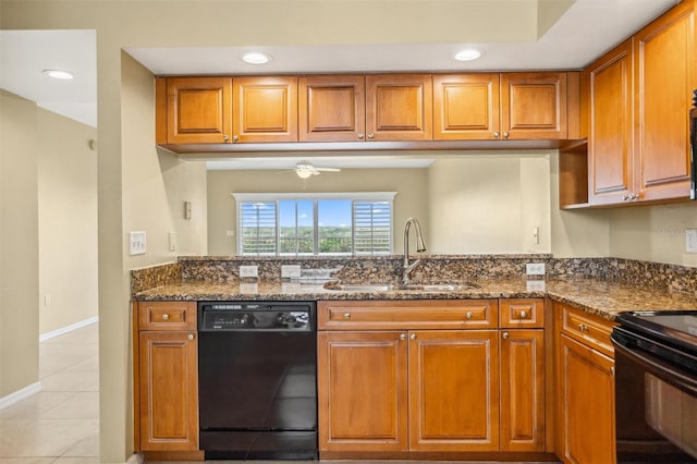 kitchen featuring dark stone countertops, black appliances, sink, and light tile patterned flooring