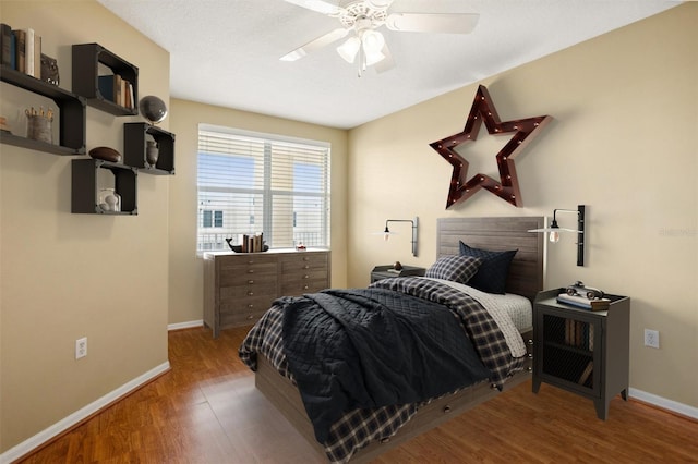 bedroom with a textured ceiling, ceiling fan, and hardwood / wood-style floors