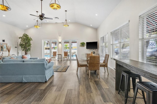 living room with dark wood-type flooring, a wealth of natural light, and ceiling fan