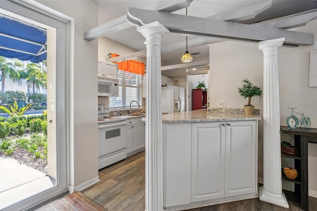 kitchen with white cabinets, hanging light fixtures, hardwood / wood-style floors, white appliances, and decorative columns