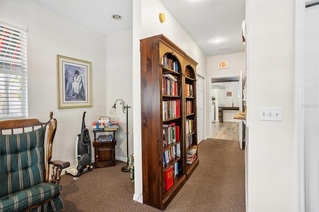 sitting room featuring dark carpet