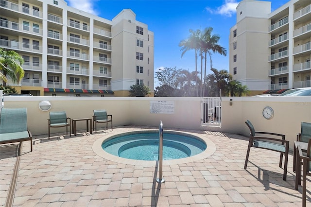 view of swimming pool with a hot tub