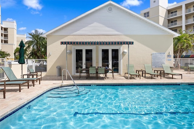 view of swimming pool featuring french doors and a patio