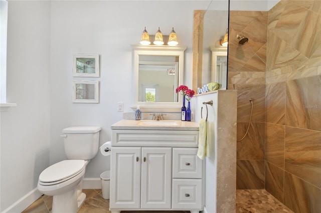 bathroom with a tile shower, tile patterned floors, vanity, and toilet