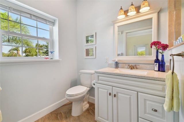 bathroom with vanity, toilet, and a wealth of natural light