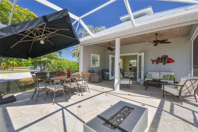 view of patio with ceiling fan and an outdoor living space with a fire pit