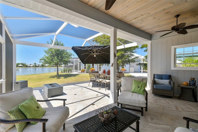 view of patio featuring a water view, outdoor lounge area, a lanai, and ceiling fan