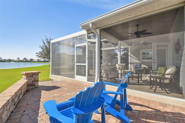 view of patio with a water view and ceiling fan