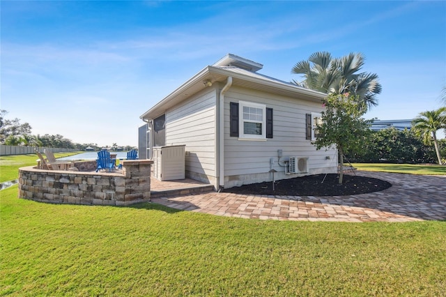 view of side of home with a lawn, a patio, and cooling unit