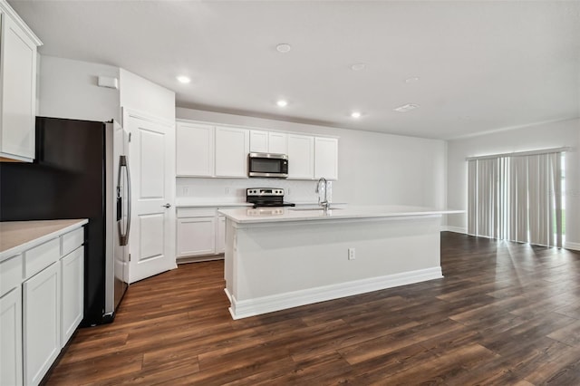 kitchen featuring a kitchen island with sink, sink, white cabinets, appliances with stainless steel finishes, and dark hardwood / wood-style flooring