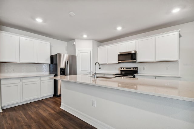 kitchen with sink, white cabinets, stainless steel appliances, dark hardwood / wood-style flooring, and light stone countertops