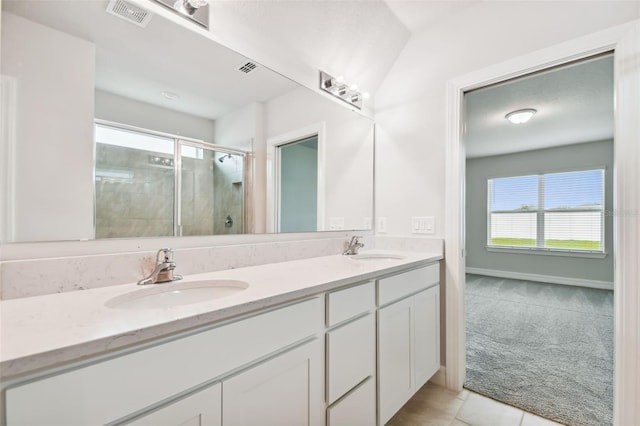 bathroom with tile patterned flooring, a shower with shower door, and vanity