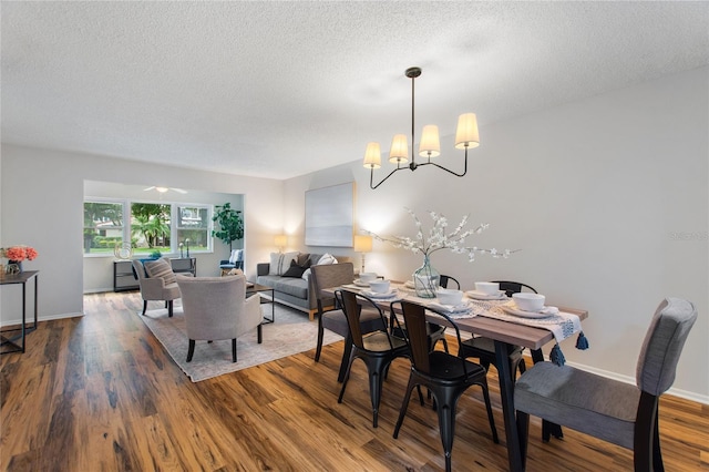 dining area featuring a textured ceiling, an inviting chandelier, and hardwood / wood-style flooring