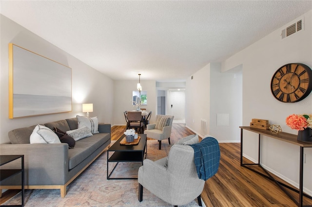 living room with a textured ceiling and hardwood / wood-style floors