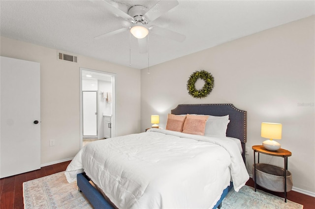 bedroom with ceiling fan, dark hardwood / wood-style floors, ensuite bathroom, and a textured ceiling