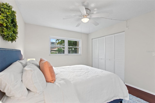 bedroom with a closet, ceiling fan, wood-type flooring, and a textured ceiling