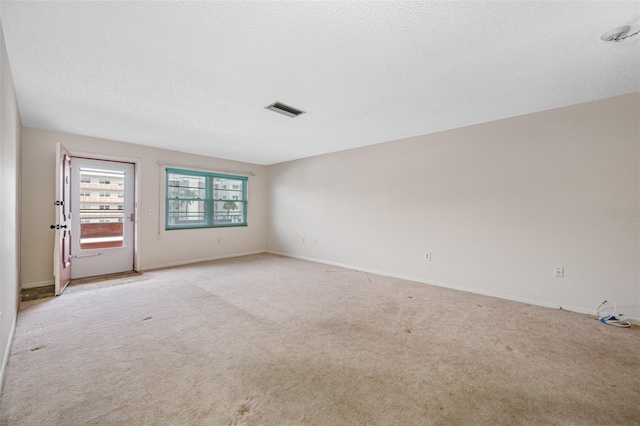 carpeted spare room with a textured ceiling