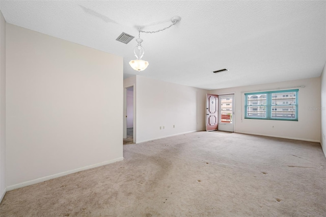 carpeted spare room with a textured ceiling