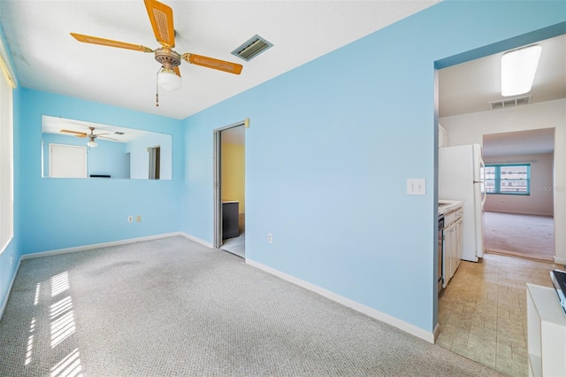 interior space featuring ceiling fan and light carpet