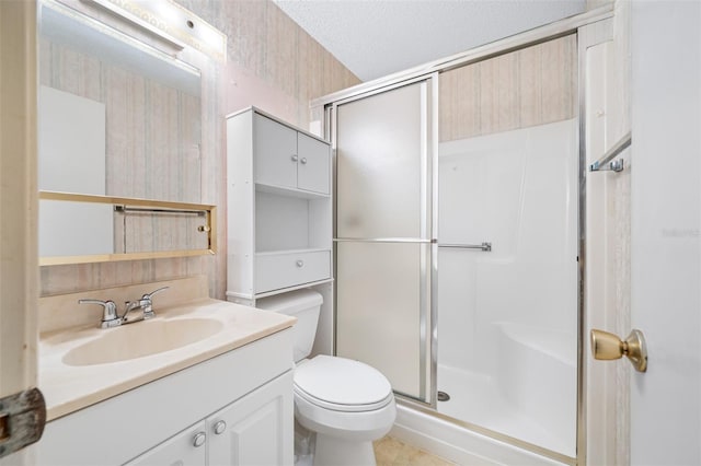 bathroom featuring toilet, walk in shower, tile patterned flooring, vanity, and a textured ceiling