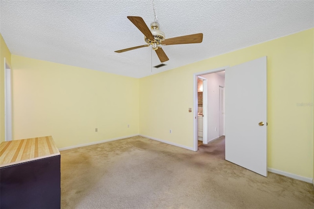 spare room featuring a textured ceiling, carpet flooring, and ceiling fan