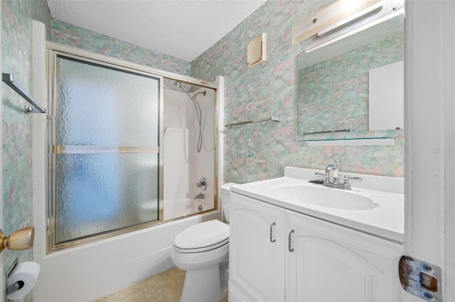 full bathroom with toilet, bath / shower combo with glass door, a textured ceiling, and vanity