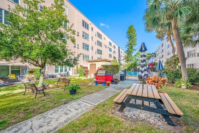 surrounding community featuring a fire pit and a yard