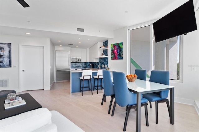 dining space featuring sink and light hardwood / wood-style floors