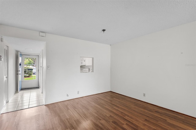 spare room featuring hardwood / wood-style floors and a textured ceiling