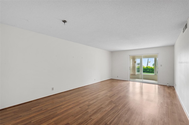 spare room featuring hardwood / wood-style floors and a textured ceiling