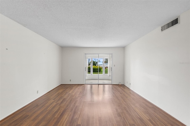 unfurnished room with dark hardwood / wood-style floors and a textured ceiling