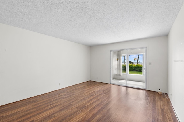 empty room featuring dark hardwood / wood-style flooring and a textured ceiling