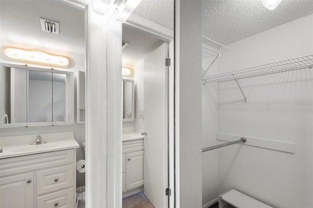 bathroom featuring a textured ceiling and vanity