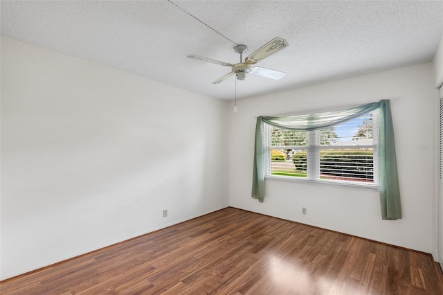 empty room with dark hardwood / wood-style flooring, ceiling fan, and a textured ceiling