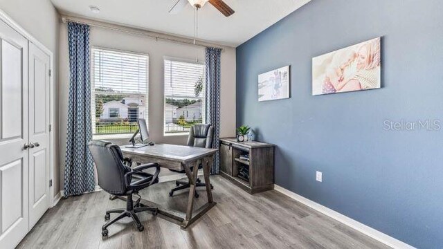 office space with a healthy amount of sunlight, ceiling fan, and light wood-type flooring