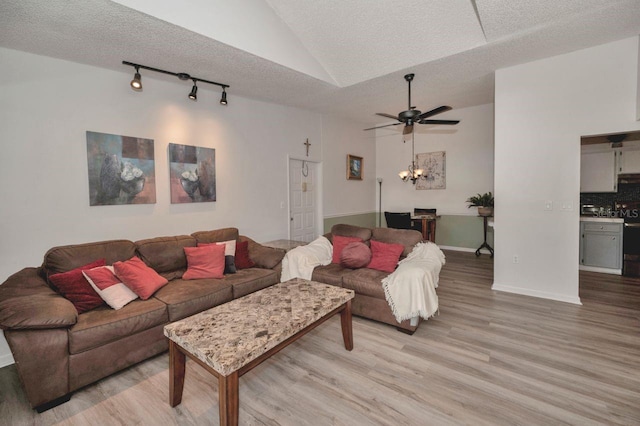 living room with light hardwood / wood-style flooring, a textured ceiling, lofted ceiling, and ceiling fan