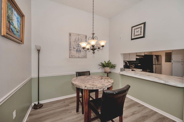 dining room with an inviting chandelier, hardwood / wood-style flooring, and sink