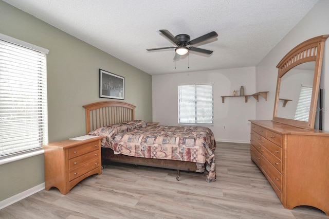 bedroom featuring a textured ceiling, light wood-type flooring, and ceiling fan