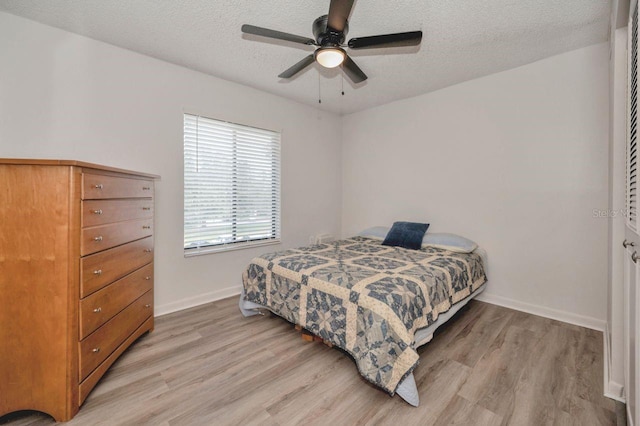 bedroom featuring a textured ceiling, light wood-type flooring, and ceiling fan