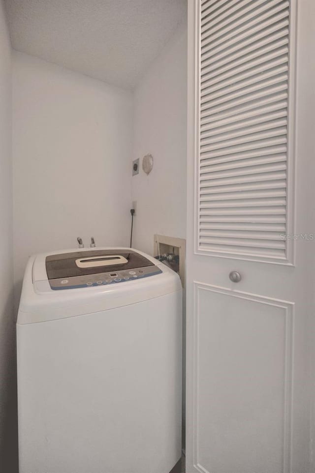 laundry room featuring washer / dryer and a textured ceiling