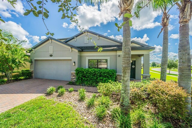 19501 Sea Myrtle Way, Tampa, FL 33647 - view of front facade featuring stucco siding, driveway, stone siding, and a garage