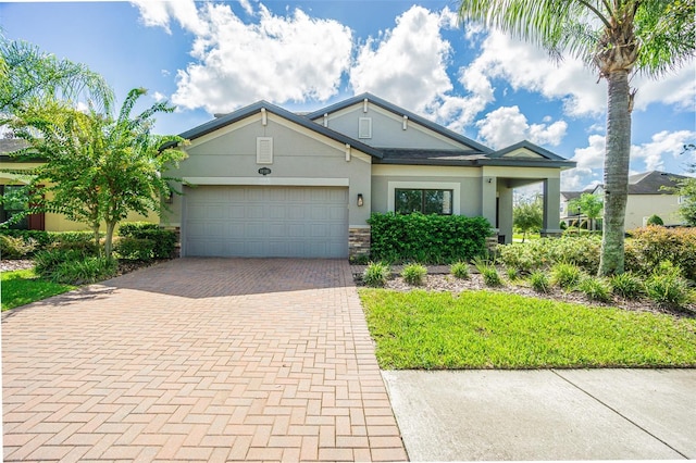 19501 Sea Myrtle Way, Tampa, FL 33647 - view of front of home featuring decorative driveway, a garage, stucco siding, and stone siding