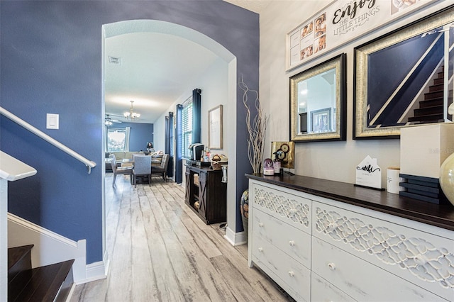 19501 Sea Myrtle Way, Tampa, FL 33647 - corridor with stairs, light wood-type flooring, arched walkways, and baseboards