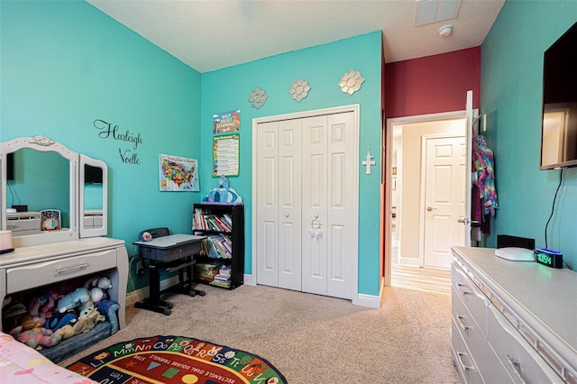 carpeted bedroom with a closet and a textured ceiling