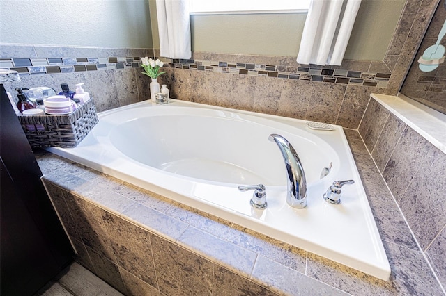 bathroom with tile walls and tiled tub