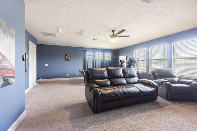 carpeted living room featuring ceiling fan and a textured ceiling