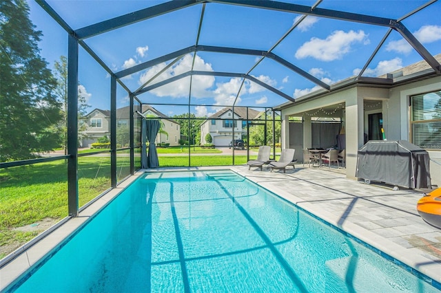 view of pool with a lanai, a patio area, a lawn, and a grill