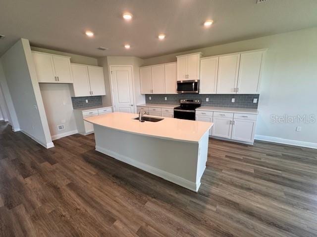 4303 Pullet Ct, Lakewood Ranch, FL 34211 - kitchen with stainless steel microwave, electric range, white cabinets, a kitchen island with sink, and recessed lighting
