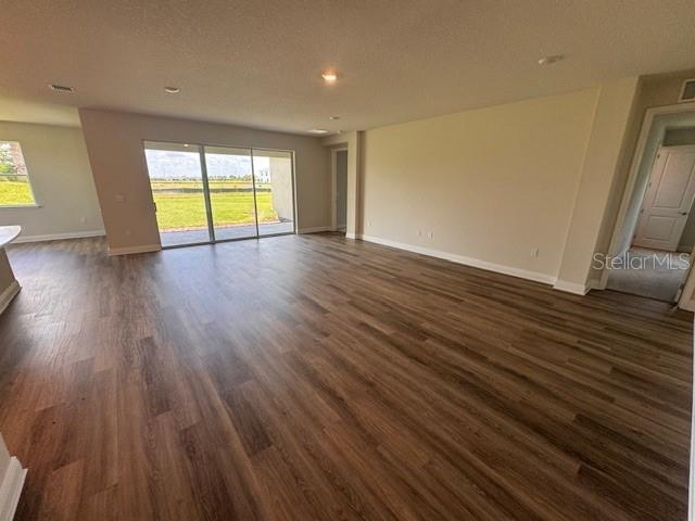 4303 Pullet Ct, Lakewood Ranch, FL 34211 - unfurnished living room featuring dark wood-style flooring and recessed lighting